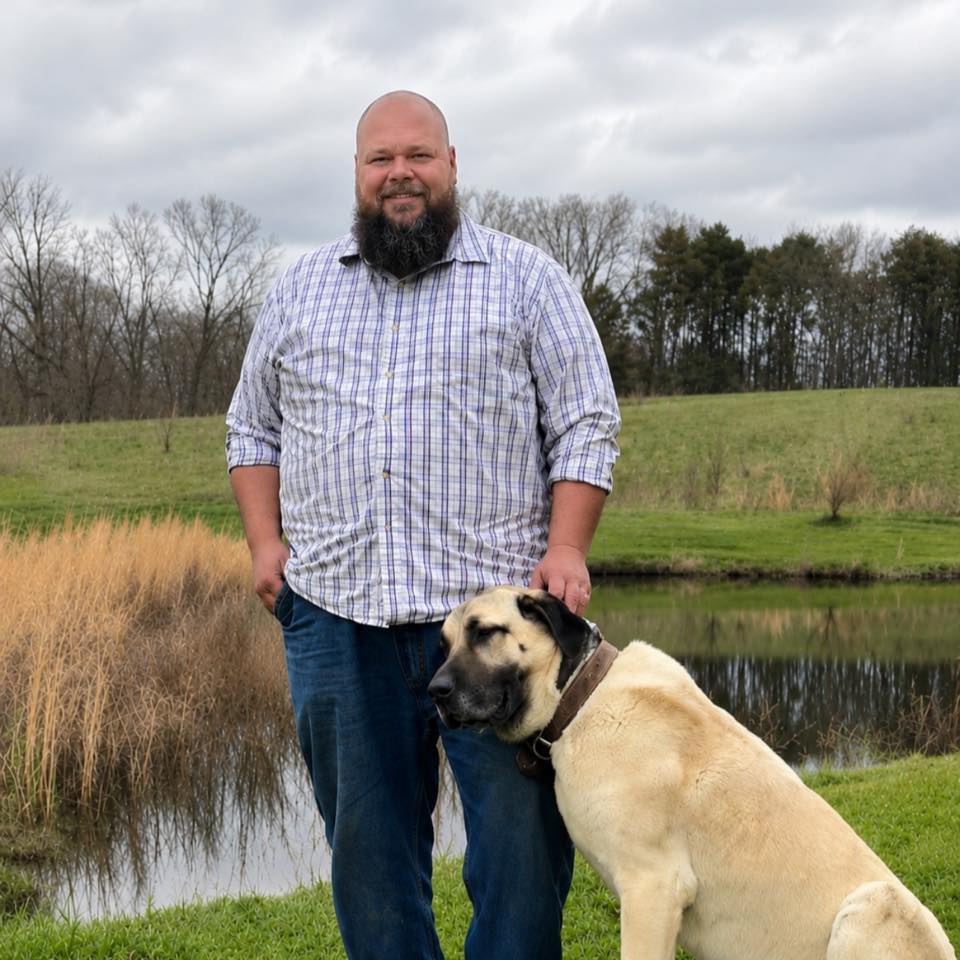 Erik Grendahl standing outdoors beside Davi near a pond